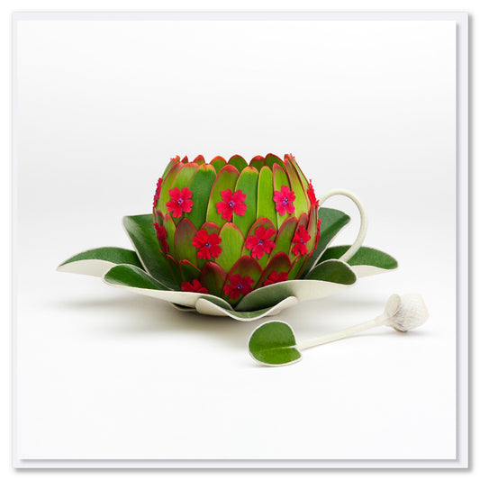 A playful greeting card featuring a cup, saucer and spoon. Created from lush green leaves and dainty red flowers. This quality square card is from Golly Gosh Creations.