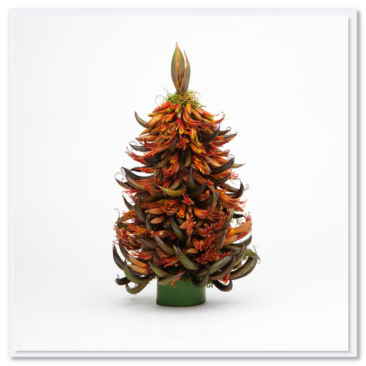 Decorative arrangement resembling a Christmas tree made from native New Zealand Flax flowers on a white background
