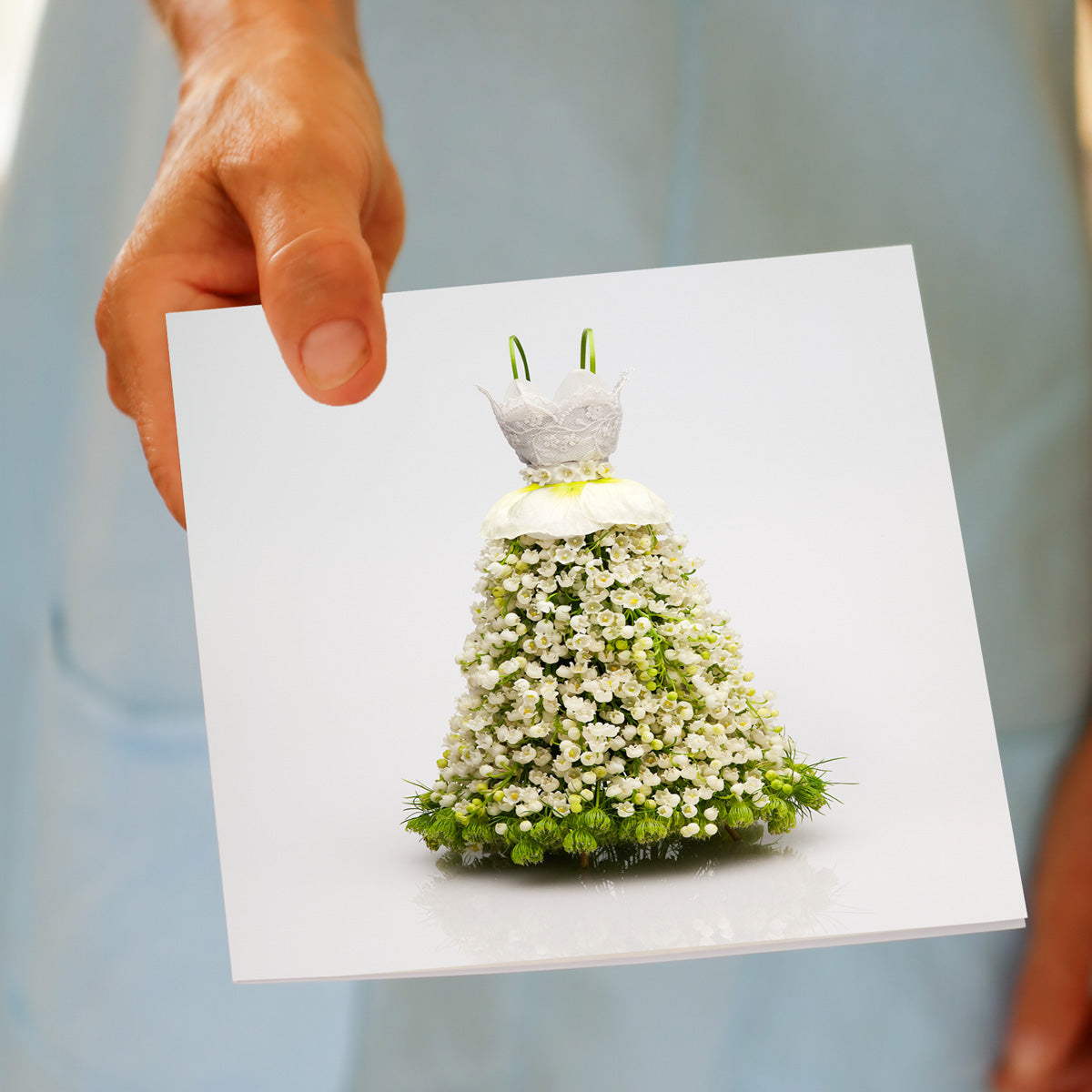 Golly Gosh Lace Bodice Dress greeting card held in hand, showing floral gown made entirely of white flowers with lace bodice and green details.