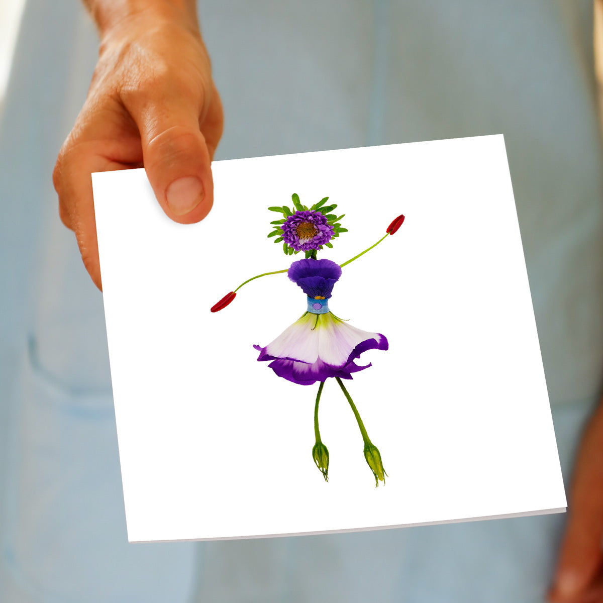 A lisianthus girl greeting card being held by hand. This generous square card is created from elegant lisianthus petals.