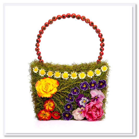 An colourful daisy chain bag greeting card adorned with vibrant dainty flowers. This quality square card is found at Golly Gosh Creations.