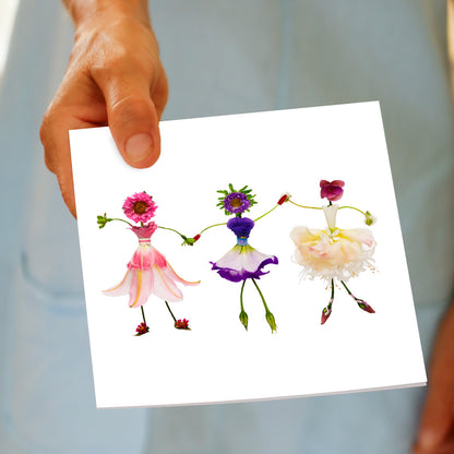 A charming dancing girls greeting card being hand held. Delicate ballerinas crafted from fresh blooms. Found at Golly Gosh Creations. Size 142 x 142 mm