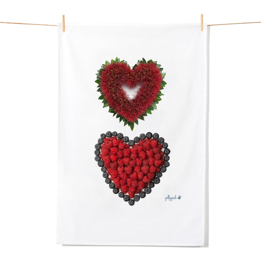 Two hearts arrangements made of red raspberries and pohutukawa blooms on a white background.