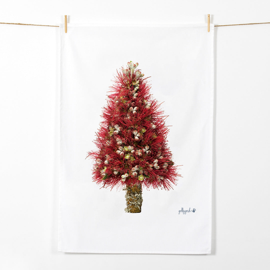 A christmas tree shape created from fresh pohutukawa flowers. A quality cotton tea towel from Golly Gosh Creations.