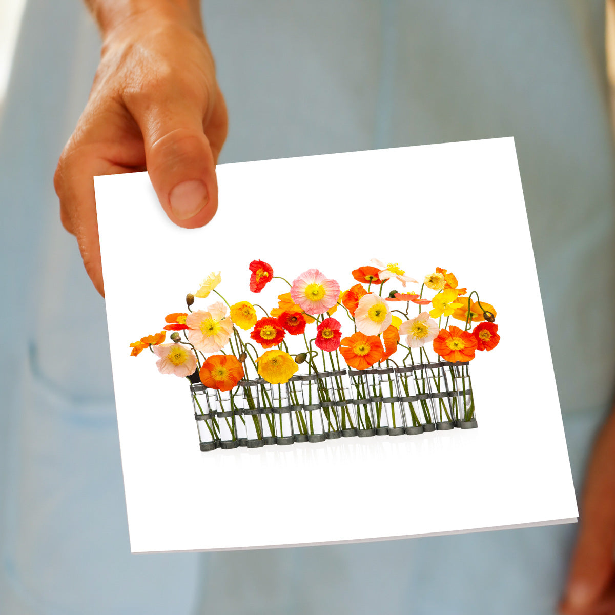 A hand held poppies vase greeting card form Golly Gosh Creations. Size 142 x 142 mm. A colourful arrangement of wild poppies in a quirky glass jug.