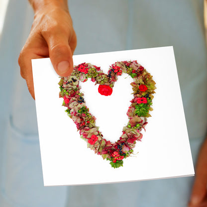 A hand held red hydrangea heart from Golly Gosh Creations. A generous square card created from red hydrangea petals and green foliage.