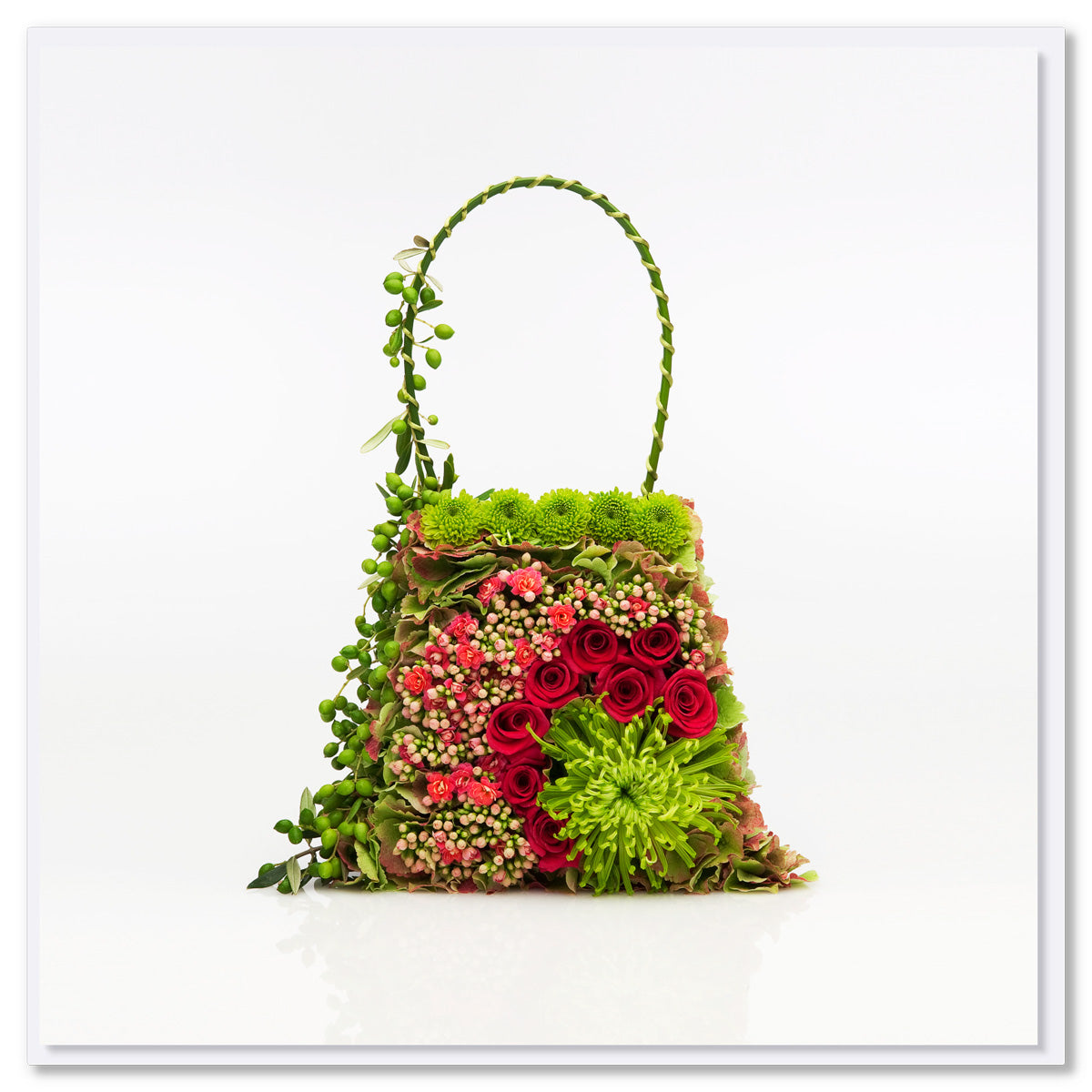 A tapestry bag greeting card by Golly Gosh Creations. This tapestry of a card is created with lush green and red flowers and blooms. Size 142 x 142 mm.