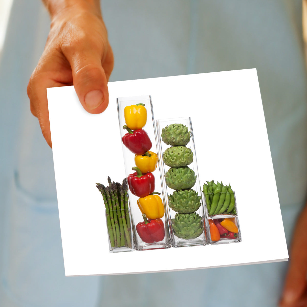 A veg vases greeting card being held by hand. This colourful, generous square card is found at Golly Gosh Creations. 